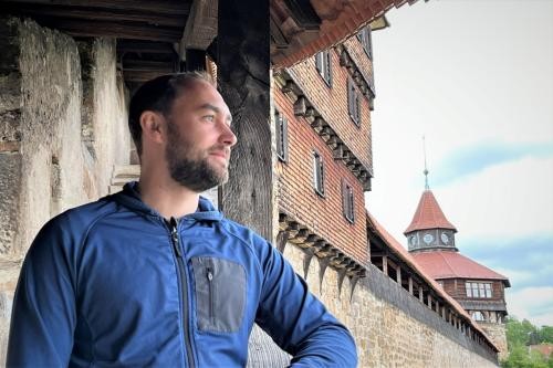 Junger Mann mit Bart blickt von der Burgstaffel der Esslinger Burg in die Ferne